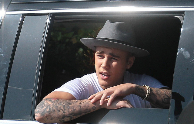 Justin Bieber seen with a Pharrell Williams hat and a grumpy expression as he made gestures; thumbs up and peace sign for the cameras...Pictured: Justin Bieber.Ref: SPL795711 030714 .Picture by: Splash News..Splash News